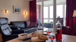 a living room with a table with a bottle of wine at Haus Horizont Fewo Nr 21 in Cuxhaven