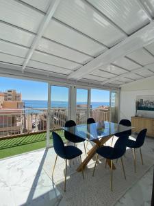 a dining room with a glass table and chairs at ARENA & MAR in El Campello
