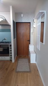 um corredor com uma porta castanha e uma cozinha em Apartament Turkusowy em Gdansk