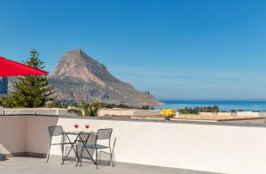 un tavolo e sedie su un balcone con vista sulle montagne di Case Vacanza Loria a Castelluzzo