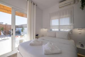 雅典Acropolis view with jacuzzi的白色卧室配有带2条毛巾的床