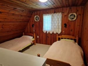 a bedroom with two beds in a log cabin at Cottage Kremna - Vila Kremna in Kremna