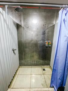 a bathroom with a shower and a tiled floor at Pupa House in Tamarindo