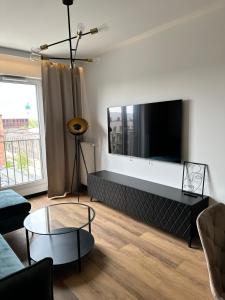 ein Wohnzimmer mit einem großen Flachbild-TV in der Unterkunft Apartament Złotowłosa przy Księżym Młynie Zupełnie NOWY!!! PARKING podziemny gratis!!! in Łódź