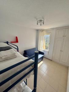a bedroom with a bunk bed and a blue chair at Apartamento en estación de esquí y montaña alto campoo in Brañavieja