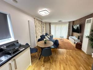 a living room with a table and chairs and a television at little hideout, Luxury Apartment in Kent