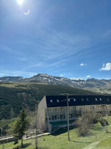 a building with snow covered mountains in the background at Apartamento en estación de esquí y montaña alto campoo in Brañavieja
