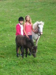 two girls are standing next to a pony and a horse at Ferienwohnung für 9 Personen ca 110 qm in Bleiburg, Kärnten Unterkärnten in Bleiburg