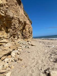 uma praia rochosa com o oceano ao fundo em Maison de ville avec terrasse 4 à 6 personnes em Lion-sur-Mer