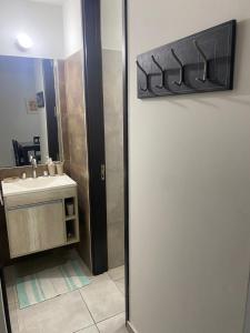 een badkamer met een douche, een wastafel en een spiegel bij Malup in Villa María