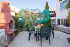 eine Terrasse mit einem Tisch, Stühlen und einem Baum in der Unterkunft Studio für 4 Personen ca 45 qm in Pjescana Uvala, Istrien Istrische Riviera in Pješčana Uvala