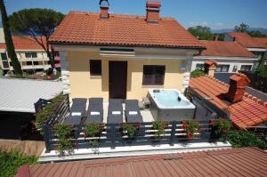 ein Haus mit einer Terrasse mit einem Whirlpool in der Unterkunft Studio für 4 Personen ca 40 qm in Njivice, Kvarner Bucht Krk in Njivice
