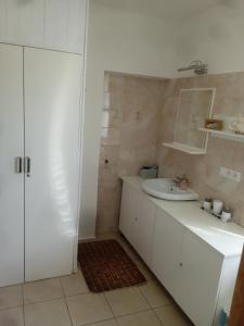 een witte badkamer met een wastafel en een spiegel bij apartman.lara in Děčín