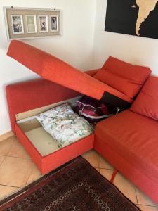 sala de estar con sofá rojo y caja en Tuscia Home Backpackers, en Orte