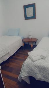 a room with two beds and a wooden table at La posada de nana in Alajuela