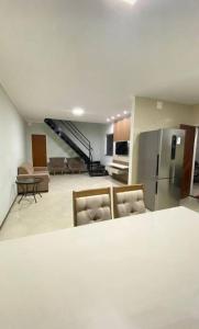 a kitchen and living room with a stainless steel refrigerator at Casa aconchego in Feira de Santana