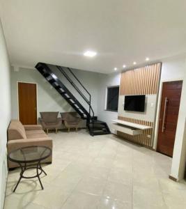 a living room with a staircase and a couch at Casa aconchego in Feira de Santana