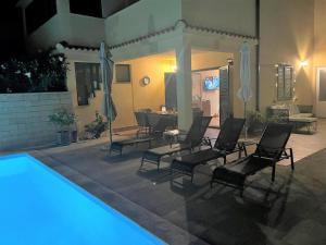 patio z krzesłami i basenem w nocy w obiekcie Ferienhaus mit Privatpool für 6 Personen ca 80 qm in Rab - Barbat, Kvarner Bucht Rab w mieście Barbat na Rabu