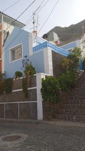 una casa azul con una escalera en la parte delantera en Casa Mrichica en Mão para Trás