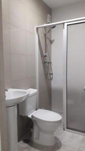 a bathroom with a toilet and a shower and a sink at Casa Mrichica in Mão para Trás