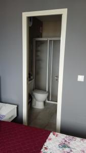 a bathroom with a toilet and a shower and a bed at Casa Mrichica in Mão para Trás