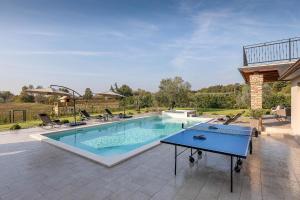 a pool with a ping pong table on a patio at Ferienhaus mit Privatpool für 7 Personen ca 200 qm in Loborika, Istrien Südküste von Istrien in Loborika