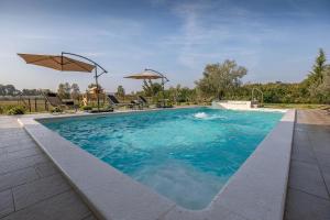 uma piscina com água azul e guarda-sóis em Ferienhaus mit Privatpool für 7 Personen ca 200 qm in Loborika, Istrien Südküste von Istrien em Loborika