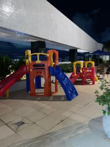 szereg kolorowego sprzętu do zabaw przed budynkiem w obiekcie Pajuçara Front Beach w mieście Maceió