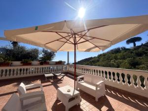 a patio with chairs and an umbrella on a balcony at Villa Costanza sorrento B&b in Sant'Agnello