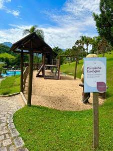 ein Park mit Spielplatz mit Schild im Gras in der Unterkunft Apartamento completo em Resort in Represa Capivari