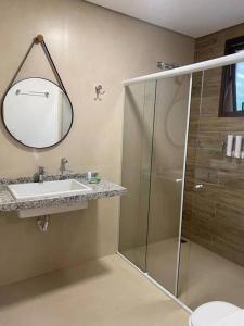 een badkamer met een douche, een wastafel en een spiegel bij Apartamento completo em Resort in Represa Capivari
