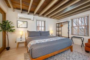 a bedroom with a bed in a room with wooden ceilings at Casa Saint Francis- King Bed-Patio & Fire Pit -2BR in Santa Fe