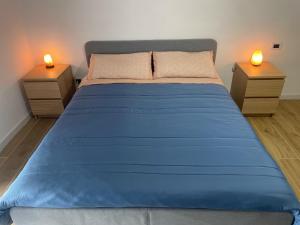 uma grande cama azul com duas mesas de cabeceira num quarto em Sandy Street Home em Nápoles