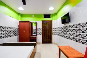 een kamer met groene en witte muren en een deur bij OYO Kohinur Guest House in Digha