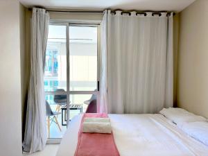 Schlafzimmer mit einem Bett und einem Fenster mit Aussicht in der Unterkunft Conforto e Sofisticação a poucos metros da Orla in Vila Velha
