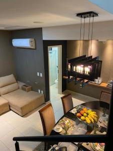 a kitchen and living room with a table with fruit on it at Pajuçara Front Beach in Maceió