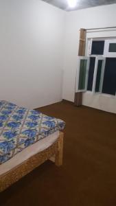 um quarto com uma cama e uma janela em Pine tree resort upper kachura lake road em Skardu