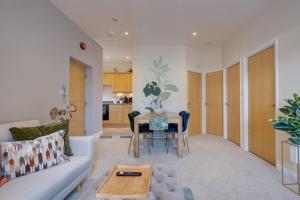 a living room with a couch and a table at Stylish Modern Town Centre Flat in Carterton