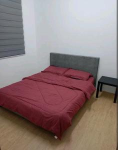 un letto con piumone rosso in camera di Bahau Taman Seri mutiara homestay a Bahau