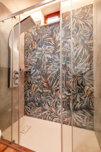 a shower stall with a floral patterned wall at Raggio di Sole in Massa Lubrense