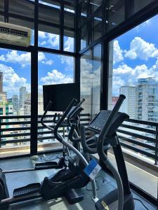 un gimnasio con cinta de correr y ordenador portátil en Romastay Itaim SP, en São Paulo