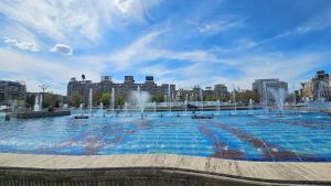 a large pool of water with fountains in a city at Private room at Ceausescu's place in Old City Unirii Square in Bucharest