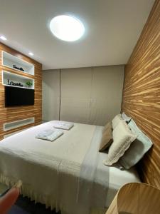 a bedroom with a bed with a television on the wall at Pajuçara Front Beach in Maceió