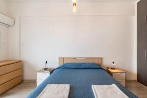 a bedroom with a blue bed and two night stands at Must Stay - Finikoudes Seaview in Larnaka +49 photos