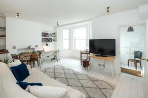 a living room with a couch and a tv at 1min to Portobello Road Market! Stylish Cosy 2 Bed Flat in the Heart of Nottinghill in London
