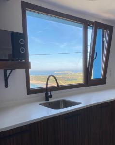 eine Küchenspüle und ein Fenster mit Meerblick in der Unterkunft EL RINCÓN DE DENVER in Suances
