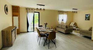 a living room with a table with chairs and a couch at Au sommet des Salazes in Salazie
