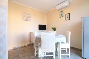 ein Esszimmer mit einem Tisch und weißen Stühlen in der Unterkunft Studio für 4 Personen ca 48 qm in Fažana, Istrien Istrische Riviera in Fažana