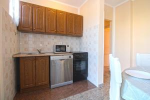 eine Küche mit Holzschränken und einem Geschirrspüler in der Unterkunft Studio für 4 Personen ca 48 qm in Fažana, Istrien Istrische Riviera in Fažana