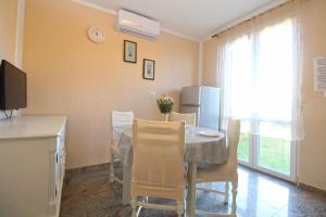 eine Küche und ein Esszimmer mit Tisch und Stühlen in der Unterkunft Studio für 4 Personen ca 48 qm in Fažana, Istrien Istrische Riviera in Fažana